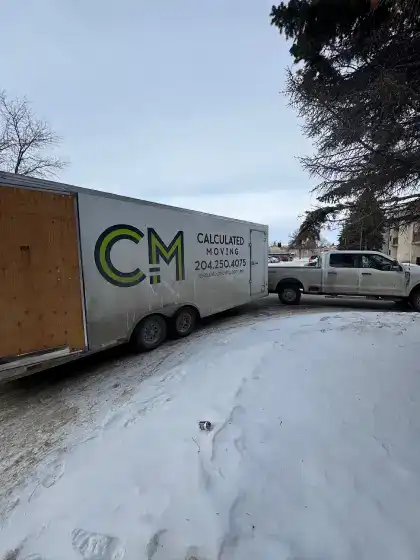Calculated Moving enclosed trailer and truck on a winter job in Winnipeg, long distance move ready for loading