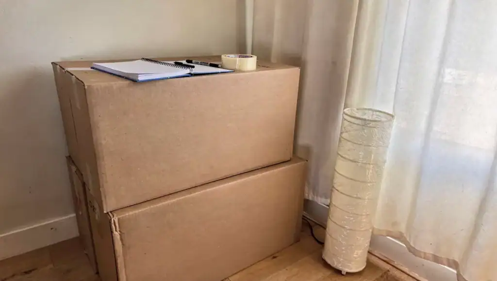 Winnipeg moving checklist, labelled moving boxes stacked beside a planning notebook